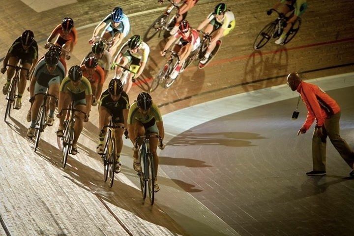 Riders racing on a velodrome track
